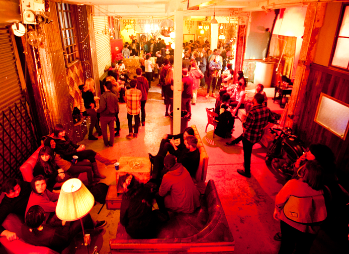 Photo of rows of books in a library with marble busts.
